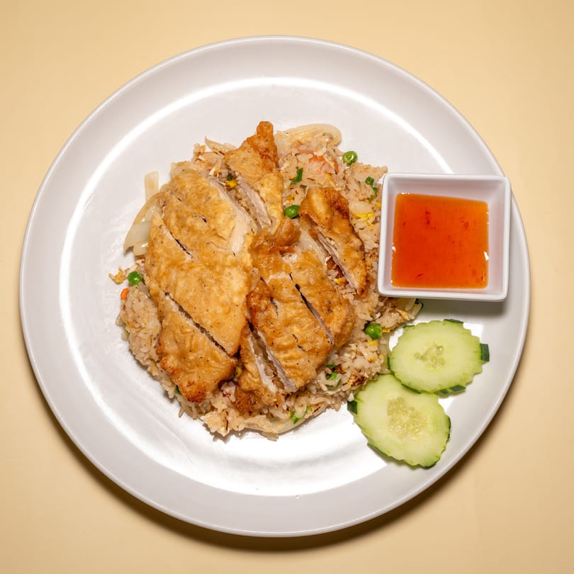 Racha Café's Thai fried rice with crispy chicken, sweet chili sauce, and cucumber slices.