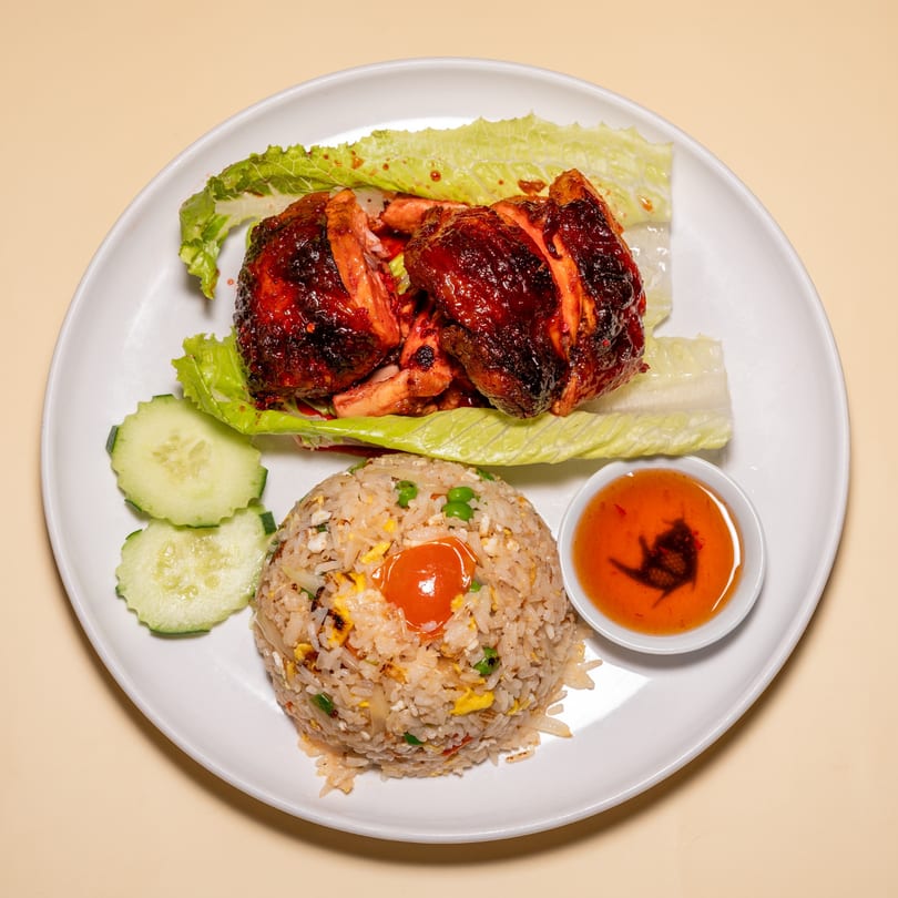 Racha Café's Thai fried chicken with lettuce, fried rice, cucumber slices, and chili sauce.